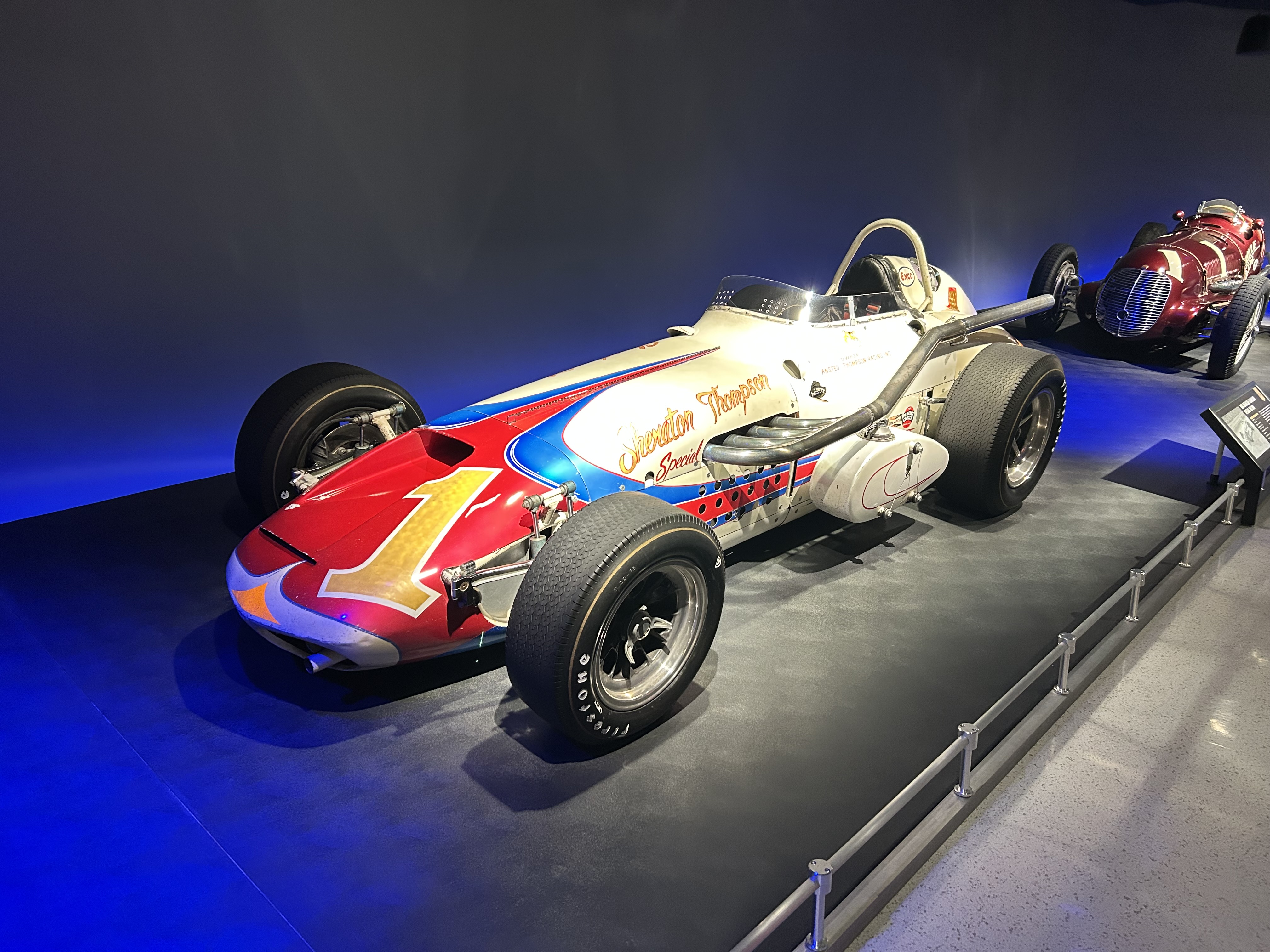 The actual cream, red and blue number 1 Sheraton-Thompson Watson-Offenhauser that A.J. Foyt drove to win the 1964 Indianapolis 500, displayed indoors and viewed from the front left.