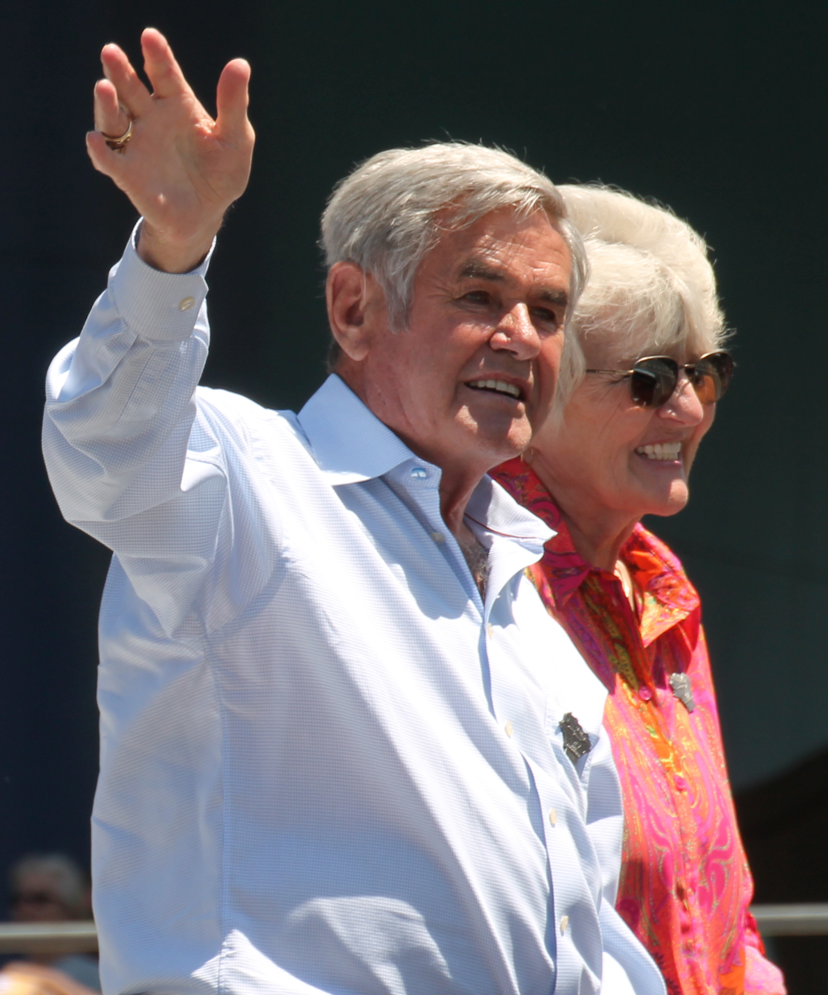 Al Unser smiling and waving at the 2015 500 Festival, with Karen Sue Unser behind him.