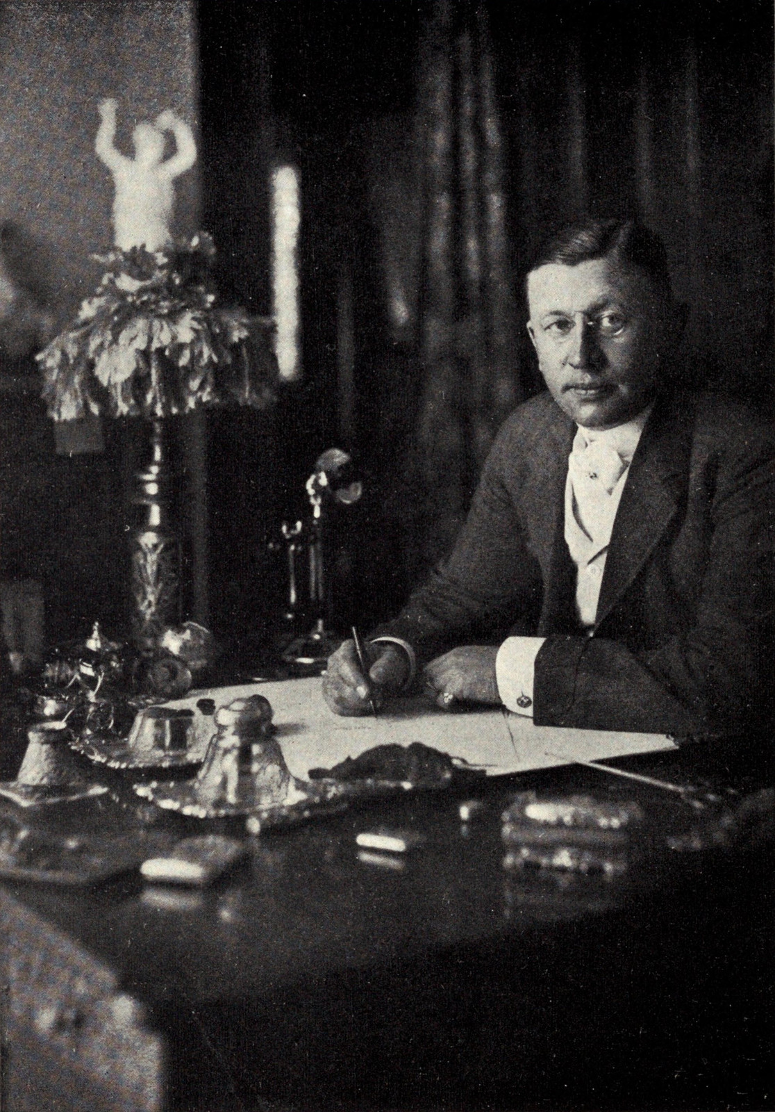 Black-and-white circa-1913 portrait of Horatio Nelson Jackson seated at a desk beside a candlestick telephone.