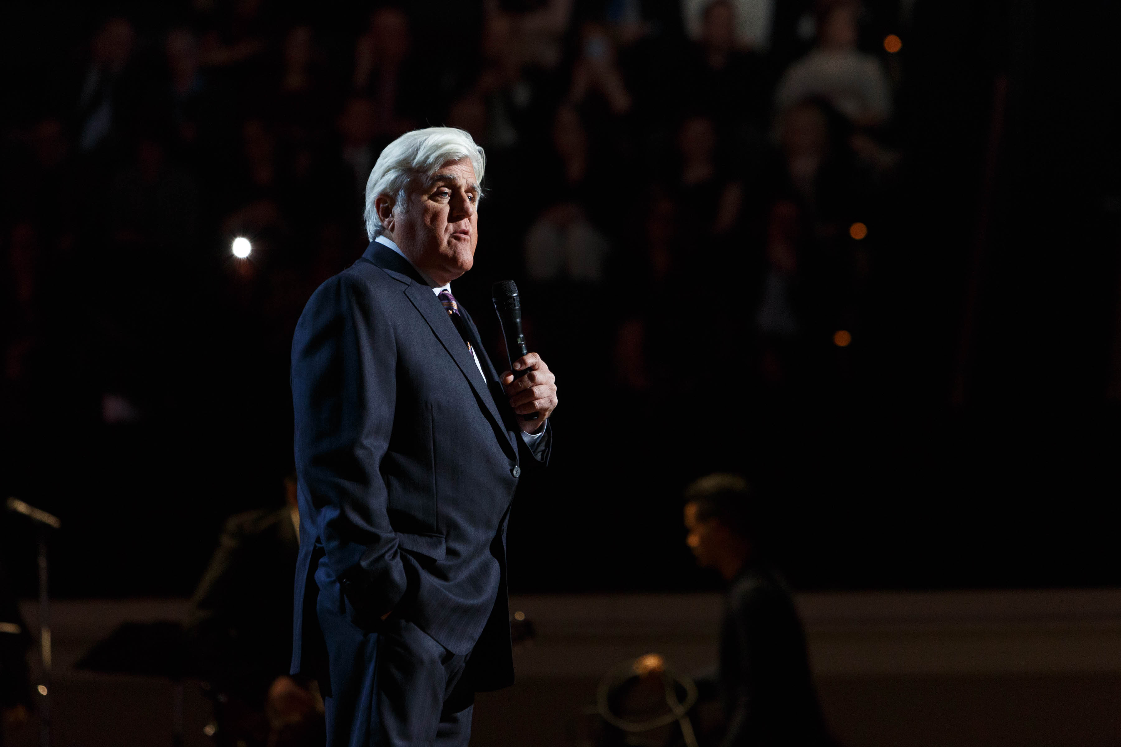 Jay Leno speaking into a microphone at the 2020 Library of Congress Gershwin Prize concert.
